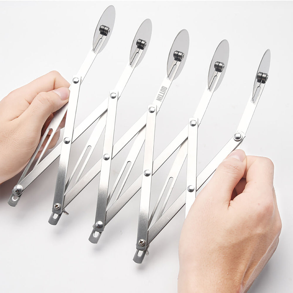 La mano de una persona ajustando un juego de seis utensilios de cocina Cortador de Masas Quttin Acero de acero inoxidable exhibidos en forma de abanico sobre un fondo blanco.