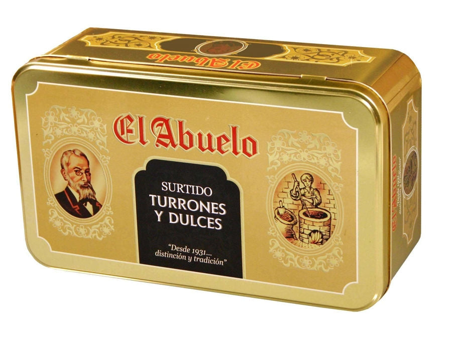 Lote 5 - Estuche Metálico de Jijona S.A. (Partida de Alequa s/n, Jijona, Alicante) es una lata rectangular dorada con ilustraciones vintage, que contiene turrones variados como Turrón Jijona, Polvorones y caramelos. Texto: "Desde 1931... distinción y tradición.