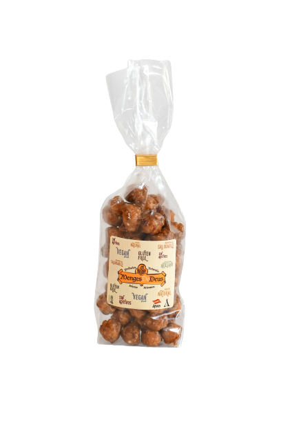 Una bolsa de plástico transparente que contiene Avellanas Garrapiñadas 1kg de Menges de Deus - Alicante - Cerdá, 104. 03009 Alicante, precintada con una brida. Incluye información nutricional y notas sobre posible contenido de cacahuetes.