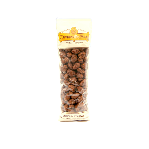 Una bolsa de plástico transparente con la etiqueta "Pistachos Garrapiñados 1kg" de Menges de Deus - Alicante - Cerdá, 104. 03009 Alicante contiene pistachos garrapiñados, indica "100% Natural" en la parte inferior e incluye información nutricional.