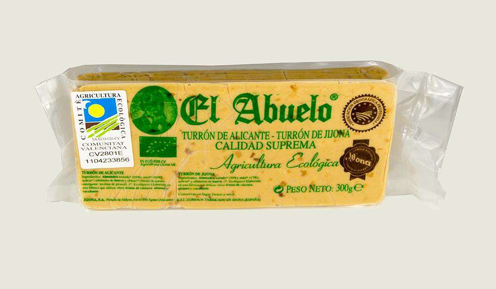 Envase rectangular de 300 g de Turrón Jijona Granulado o Refinado Ecológico El Abuelo de Jijona S.A., con etiquetas de calidad ecológica y suprema, sellos de certificación, detalles del producto y tostada de almendra destacada en la parte frontal.