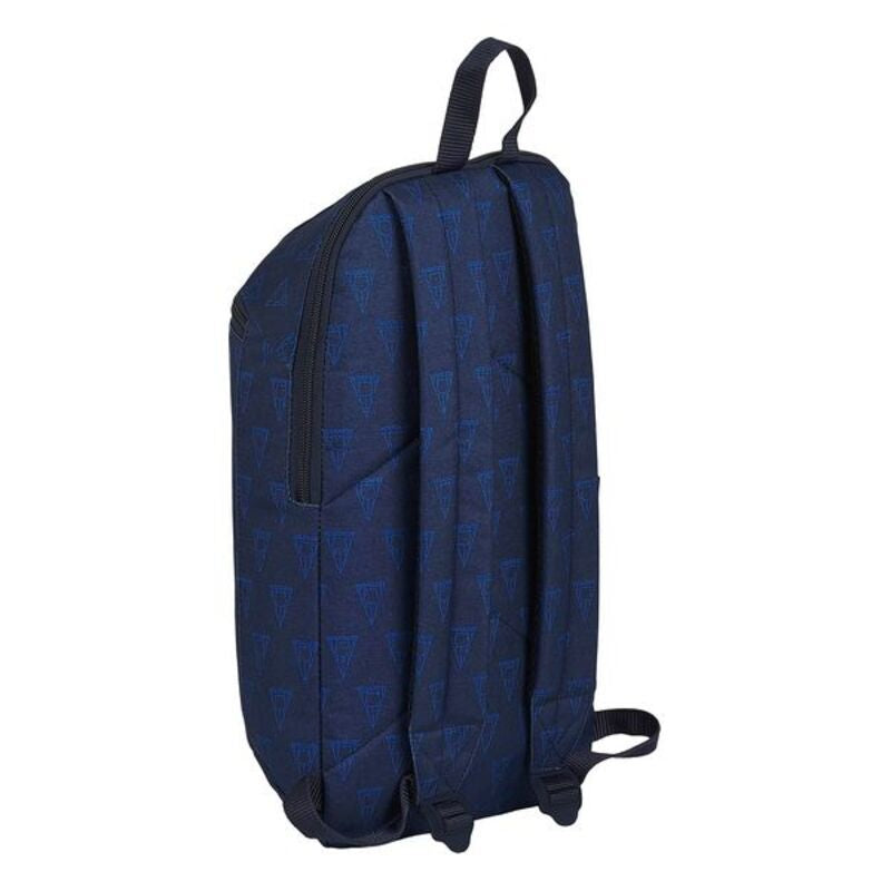 La Mochila Casual F.C. Barcelona Azul marino, de la reconocida marca F.C. Barcelona, presenta un color azul oscuro con correas negras y un sutil patrón de triángulos. Se muestra en posición vertical y en ángulo para mostrar tanto el costado como parte de la espalda, lo que la convierte en una mochila casual ideal.