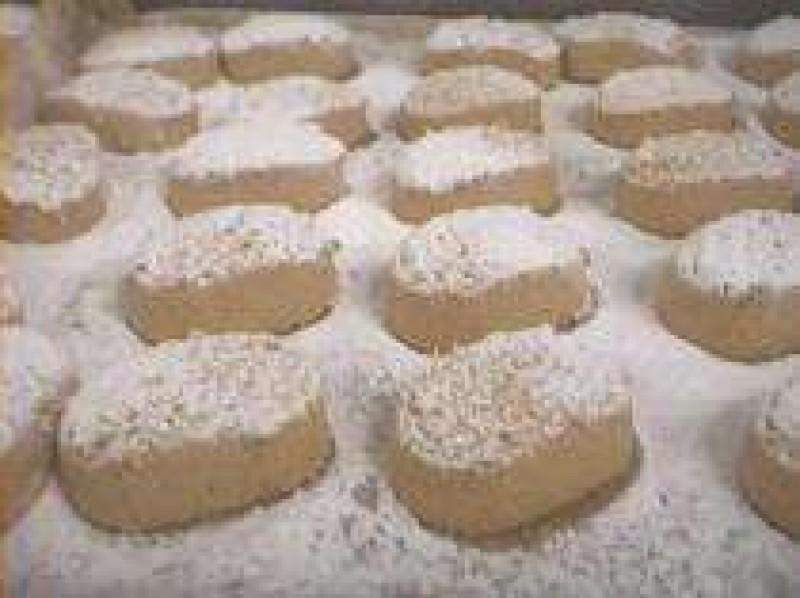 Polvorones de Almendra sin azúcares añadidos (Jijona S.A., caja de 500g) se presentan en una bandeja, cubiertos con su característico recubrimiento y colocados sobre una fina capa de polvo.